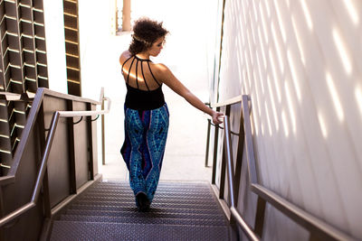 Rear view of woman moving down on steps