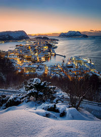 High angle view of townscape by sea against clear sky