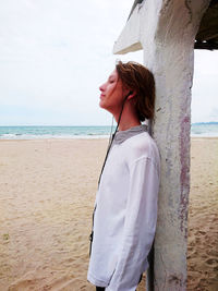 Side view of young woman standing on beach