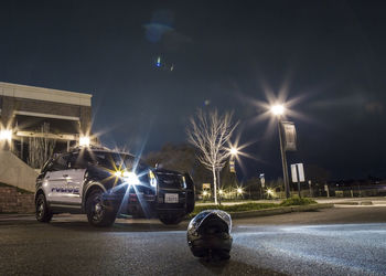 Cars on illuminated road against sky at night