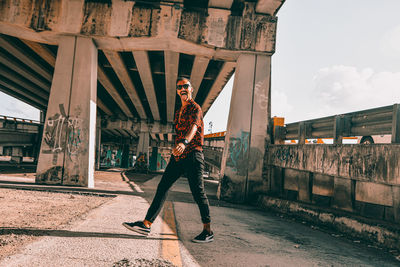 Full length portrait of young man standing against built structure