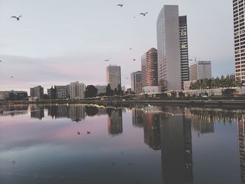 Reflection of buildings in city against sky