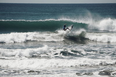 Man surfing in sea against sky