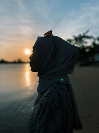 A lonely woman in front of sunset at beautiful beach