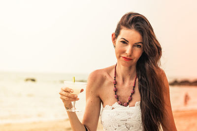 Portrait of young woman drinking water from glass