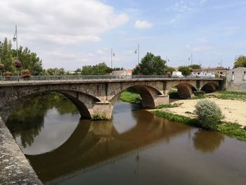 Arch bridge over river against sky