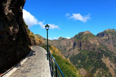 Road amidst mountains against blue sky