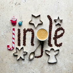 Directly above shot of jingle text with christmas objects on concrete