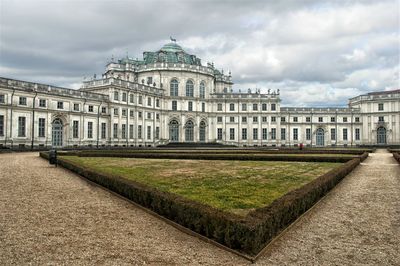 Facade of historical building against cloudy sky