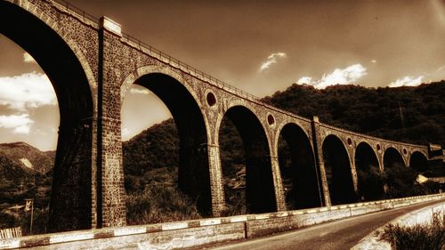 Bridge against cloudy sky