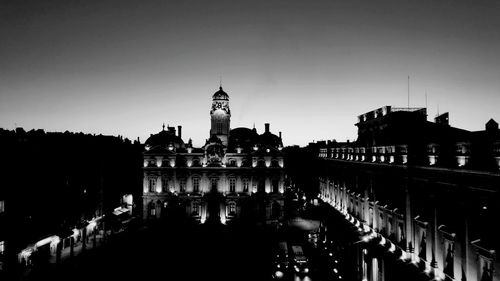 Silhouette buildings against sky at dusk