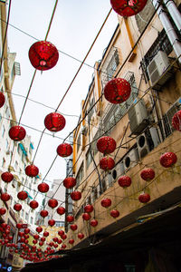 Low angle view of lanterns hanging by building