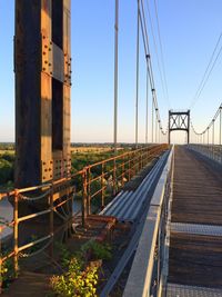 Bridge over road against clear sky in city