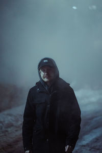 Portrait of young man standing against sky