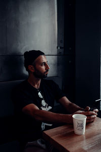 Young man drinking coffee cup on table