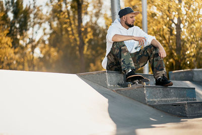 Low section of man with skateboard in park