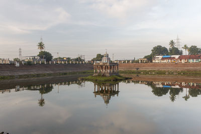 Reflection of building on lake against sky