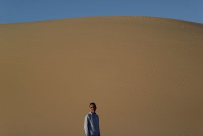 Man standing on desert against clear sky