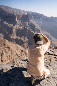 Rear view of woman standing on mountain