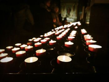 Lit candles on table in illuminated building