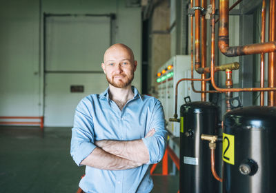 Adult bald smiling attractive man forty years with beard in blue shirt businessman, engineer 