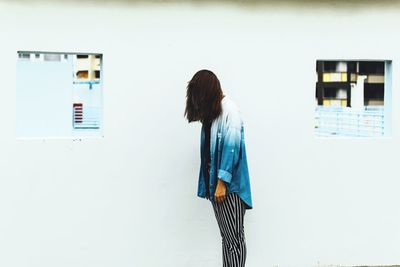 Side view of a man standing against the wall