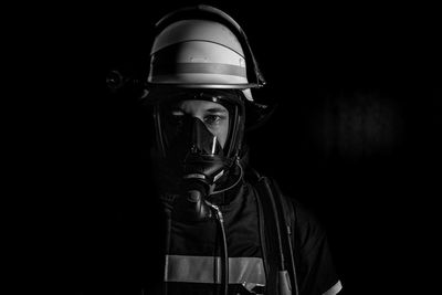 Man wearing hat standing against black background