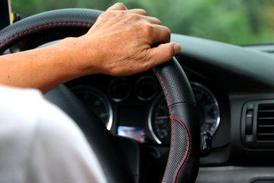 Midsection of man using mobile phone in car