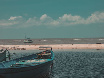 Sailboats moored on sea against sky