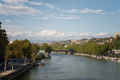 Scenic view of river by buildings against sky