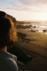 Rear view of woman looking at sea against sky