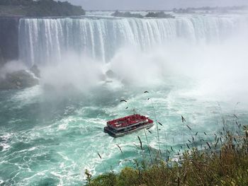 View of waterfall with lake in foreground