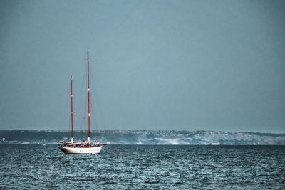 Sailboat sailing on sea against sky