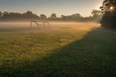 Goal post on field during sunset