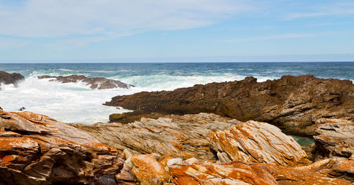 Rock formation on beach against sky