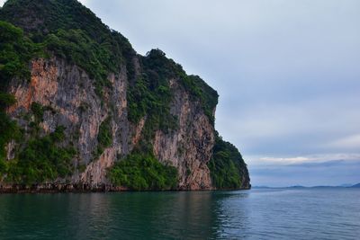 Scenic view of sea by cliff against sky