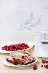 High angle view of red currants with cake slices on table