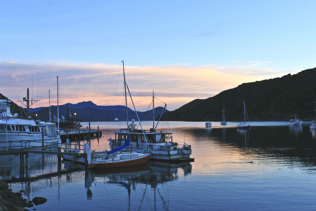 nautical vessel, water, transportation, boat, moored, mode of transport, sky, mountain, sunset, waterfront, reflection, lake, tranquil scene, tranquility, scenics, harbor, beauty in nature, nature, cloud - sky, dusk