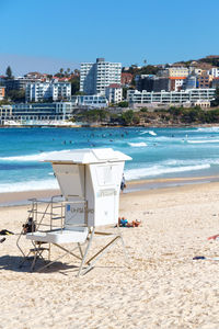 Deck chairs on beach against buildings in city