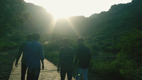 Rear view of people walking on mountain