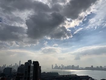 Buildings in city against cloudy sky