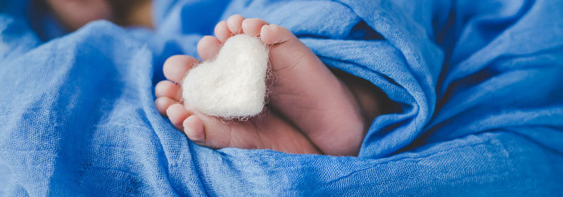 Baby with heart shaped object sleeping on bed at home