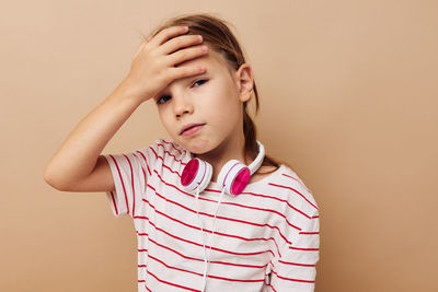 Portrait of depressed girl against beige background