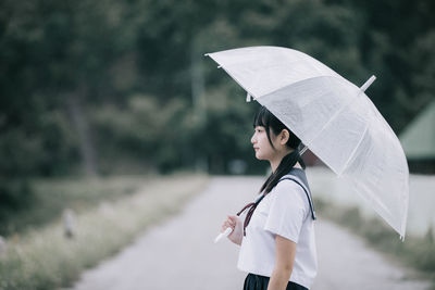 Side view of woman with umbrella