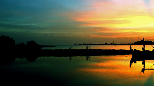 Scenic view of lake against orange sky