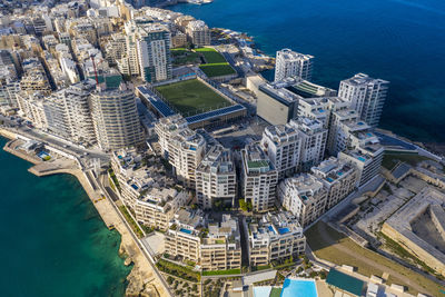 Malta, central region, sliema, aerial view of soccer field, apartments and hotels of tigne point peninsula