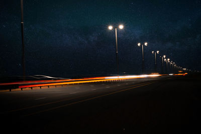 Light trails on street against sky at night