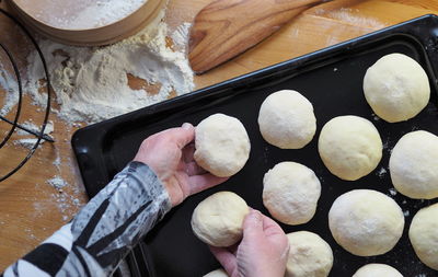 The process of cutting the dough into pieces for baking homemade buns.the woman's hands .