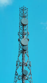 Low angle view of electricity pylon against blue sky