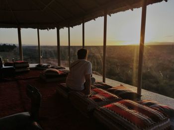 Rear view of man working at sunset